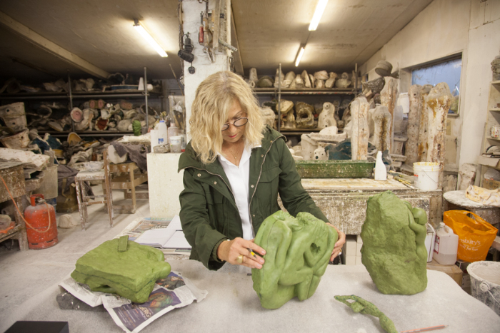 Ahuva stands in the sculpture studio checking three moulds she has made of stone sculptures ready to take to the foundry for creating in glass.