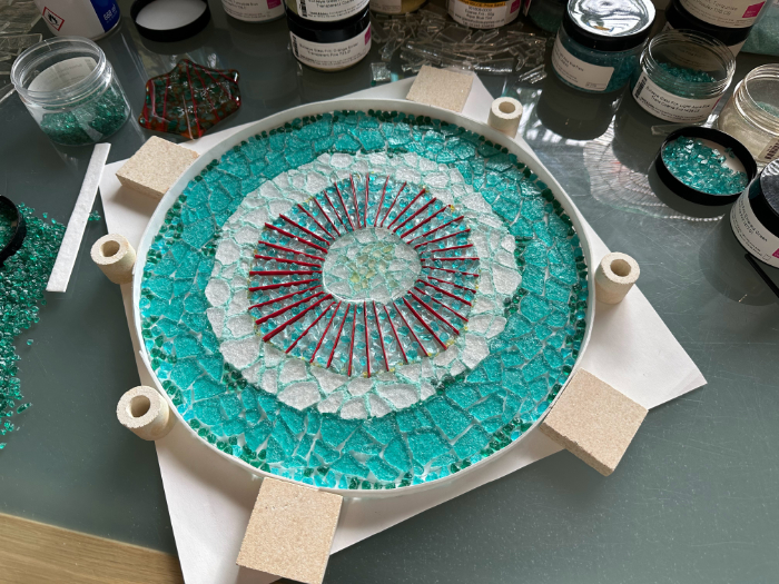 Fused glass pieces in a mould awaiting firing, showing the intricacy of the design of a plant cell.