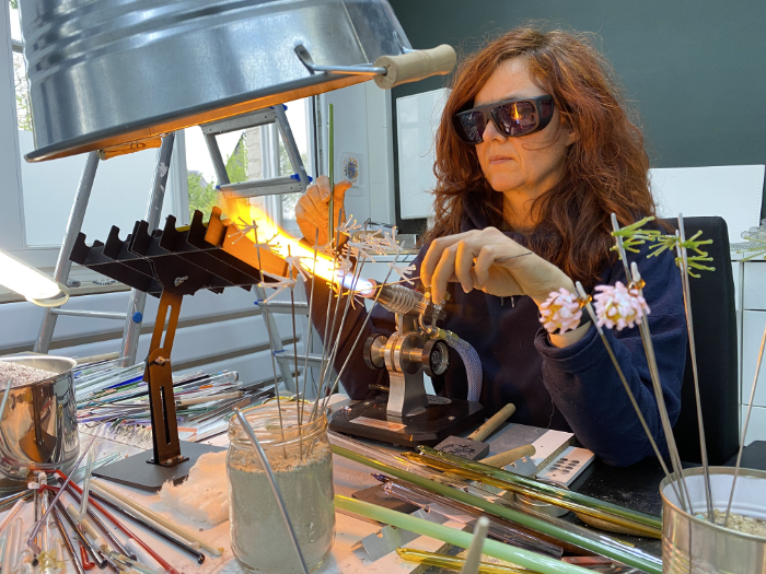 Lea Lenhart at the torch in her studio making flameworked glass