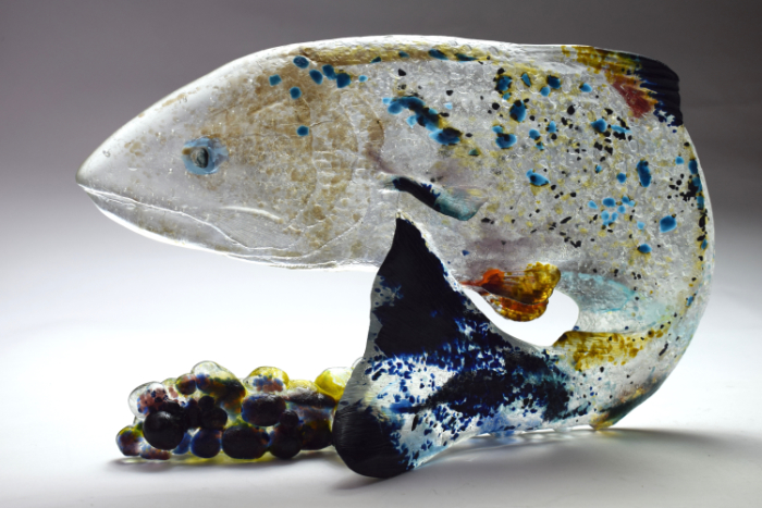 Cast glass fish sculpture standing on a table