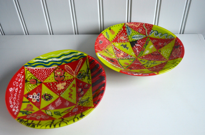 Fused and slumped glass bowls made with primary school children in Pembrokeshire featuring a patchwork effect in lime green and red.