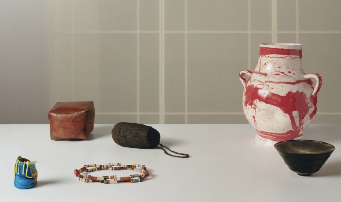 A selection of craft items on a table made in a variety of materials that were all finalists in the Loewe Craft Prize 2025. View includes a glass vessel by Scott Chaseling.