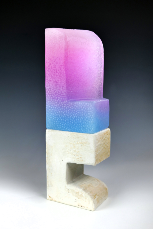 ‘Calling’ is made from kiln-cast and cold-worked glass and cast concrete. It features pink glass fading into blue glass in an angular form on top of a white concrete base of angular form.