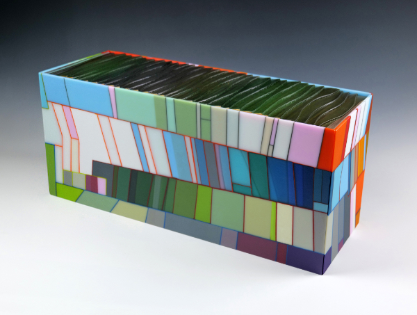 A rectangular kiln-formed glass artwork featuring angular lines and multicoloured glass.