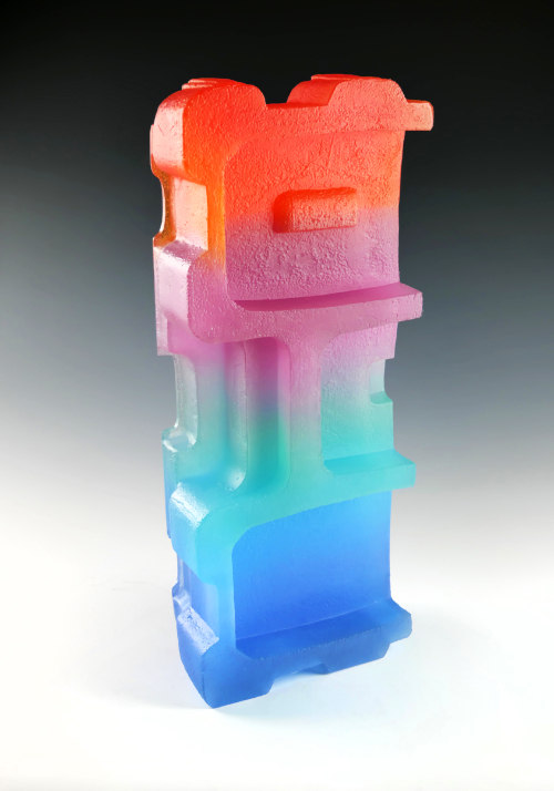 'Eternal Optimist' is a vertical sculpture in glass featuring blue glass, aqua glass, pink glass and orange glass formed into an angular structure.