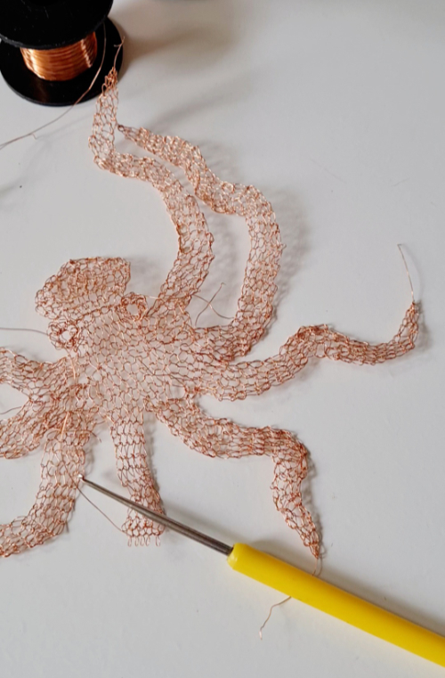 Copper wire crocheted into an octopus shape that will be incorporated into a glass vessel.