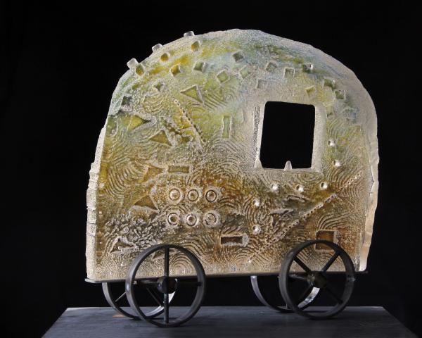 Caravan-style cast glass vehicle with steel wheels called Get in and join us on the journey.