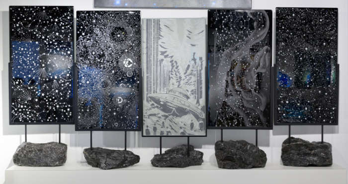 A series of 5 space-themed glass panels mounted on rocks.