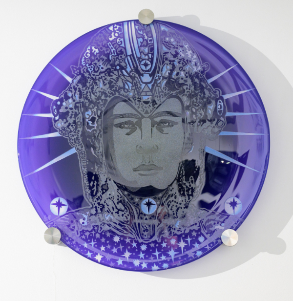 A circular purple glass wall panel featuring an alien being's head by Trish Duggan.