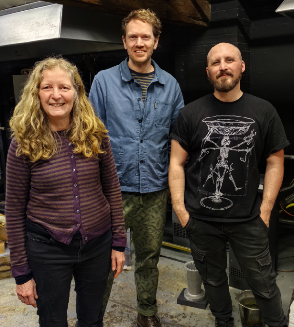 Glass artists Rachel Welford, Matt Nickels and Elliot Walker standing facing the camera in Elliot's hotshot.