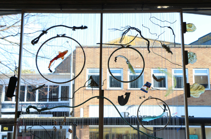 Top section of installation displayed in a large window featuring cast glass, mixed media, foraged objects and touch-interactive audio. 