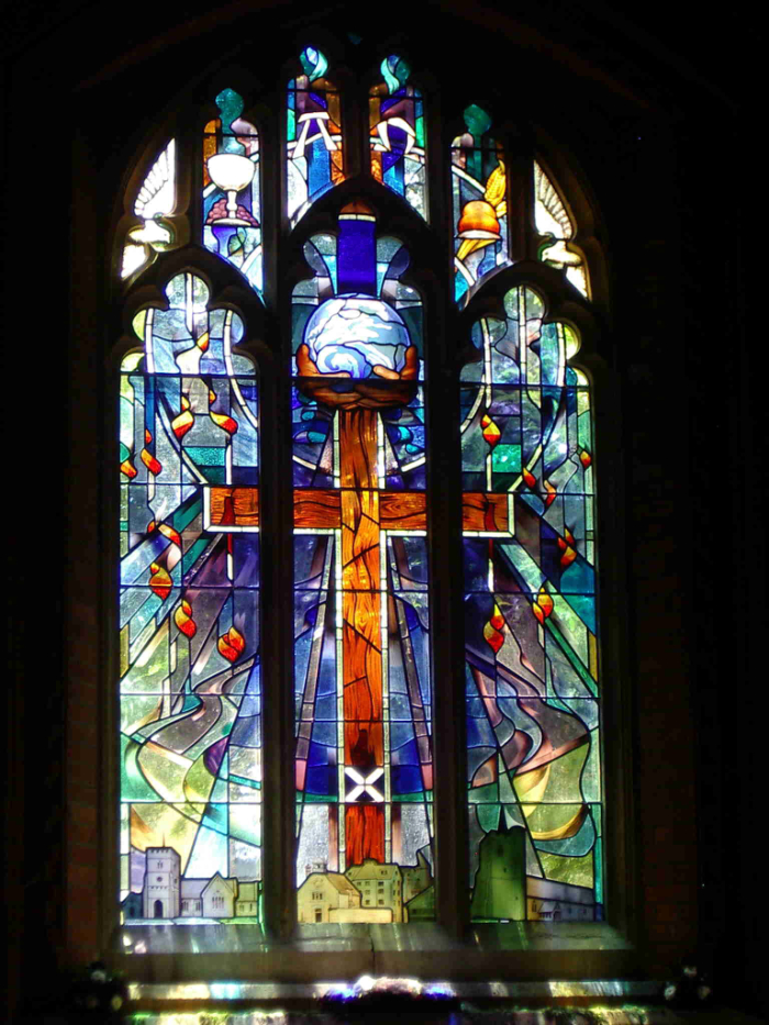 Stained glass window at St Andrew's Church in Standstead Abbots featuring rich Red Cross in the centre.