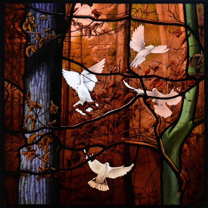 Highly detailed painted stained glass scene featuring white doves rising in a warm brown toned woodland scene.