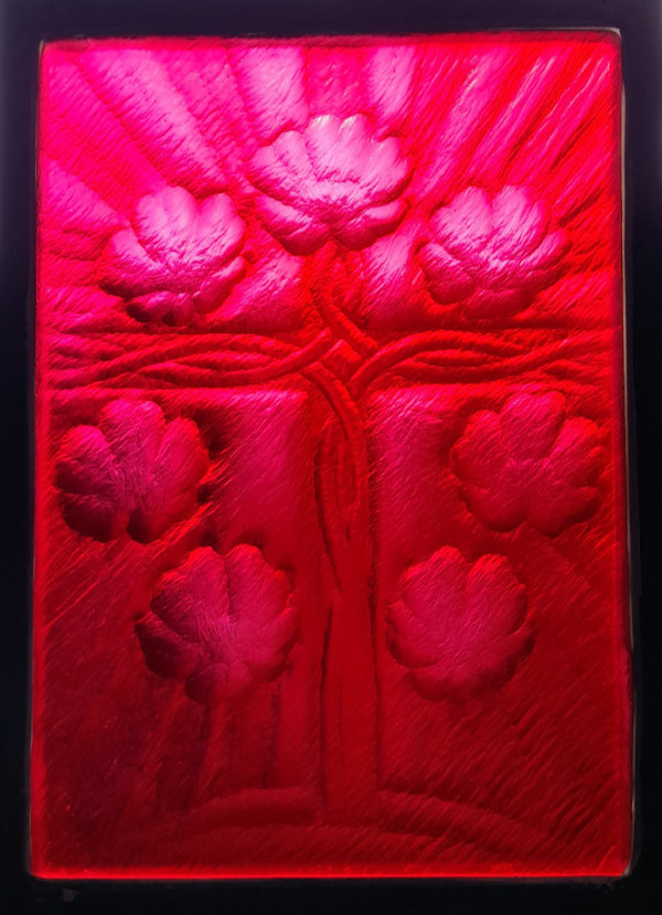 A rich red-pink carved glass monochrome panel entitled 'Rose Cross', featuring a central cross with a Celtic-feel design surrounded by 7 large flower designs.